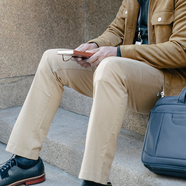 Hombre sentado con una pantalón chino beige